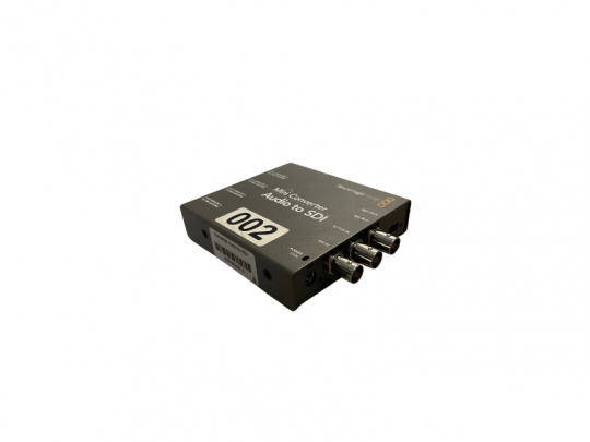 Blackmagic Audio to SDI Mini-Konverter mit drei BNC-Anschlüssen und Etikett 002, freigestellt auf weißem Hintergrund.